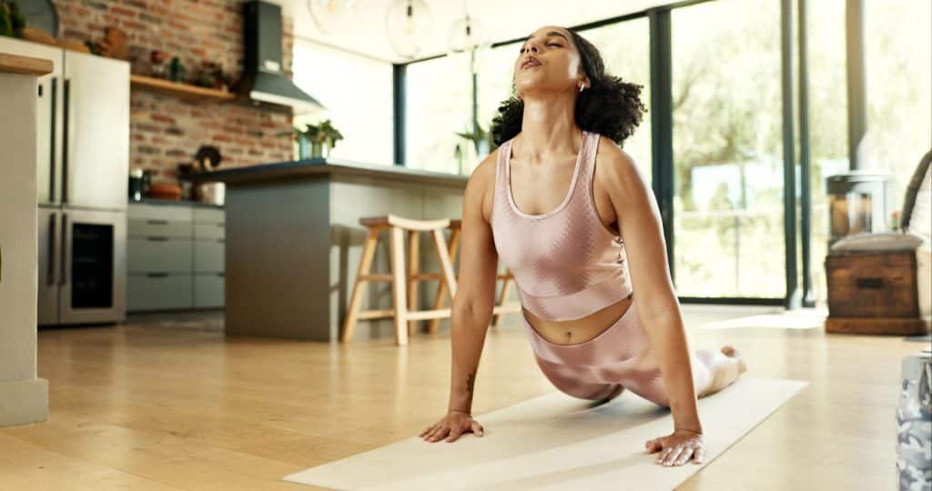 Woman doing cobra pose at home.