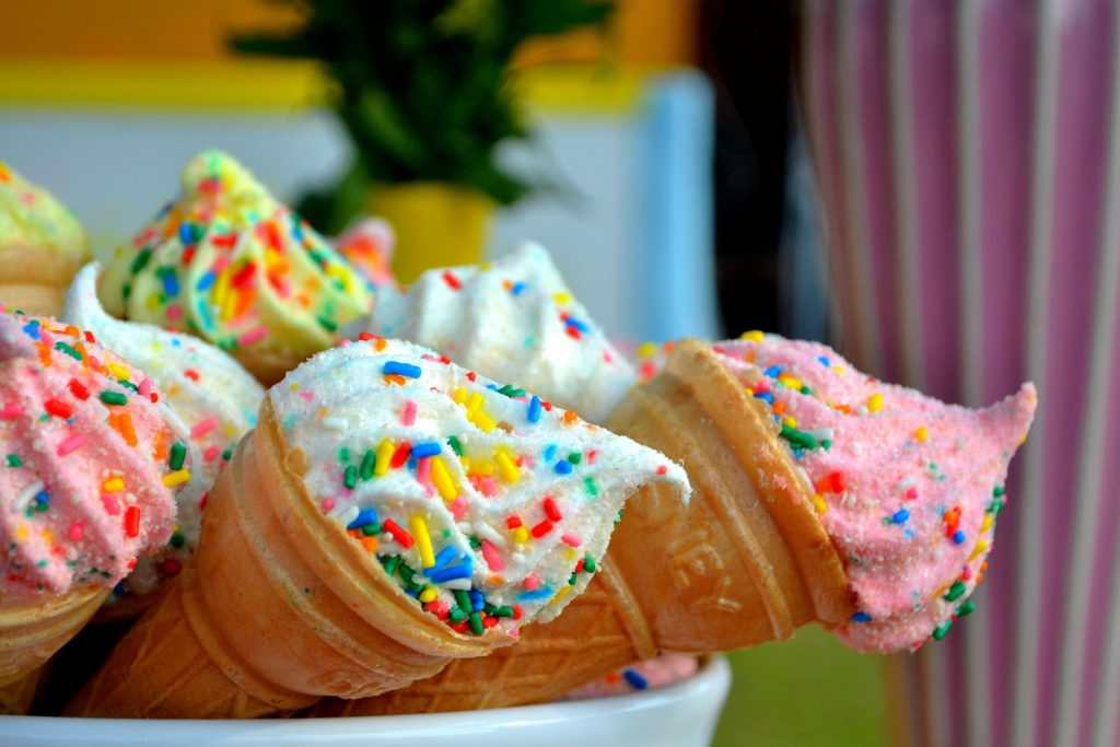 Sprinkled ice cream in cones inside of a bowl.