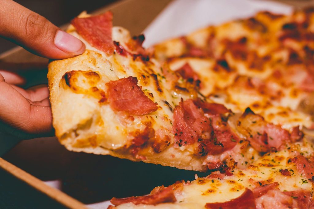 Man picking up a slice of pizza.